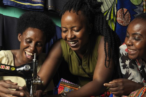 Three female BRAC participants smiling and working together - youth empowerment