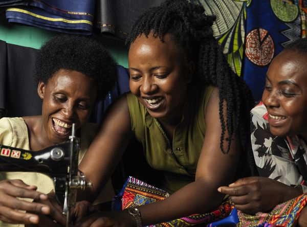 Three female BRAC participants smiling and working together - youth empowerment