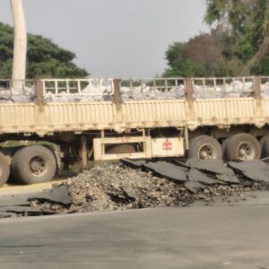 A roadway is covered in rubble as the road is significantly damaged.
