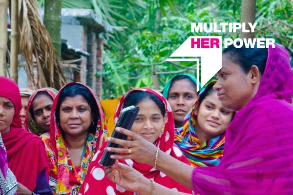 Image of a microfinance borrower group in Bangladesh with "Multiply Her Power" graphic overlay
