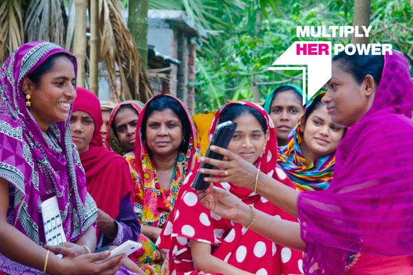Image of a microfinance borrower group in Bangladesh with "Multiply Her Power" graphic overlay