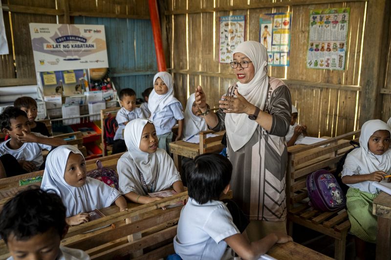 A teacher in a BRAC school in the Philippines speaks to class full of young students
