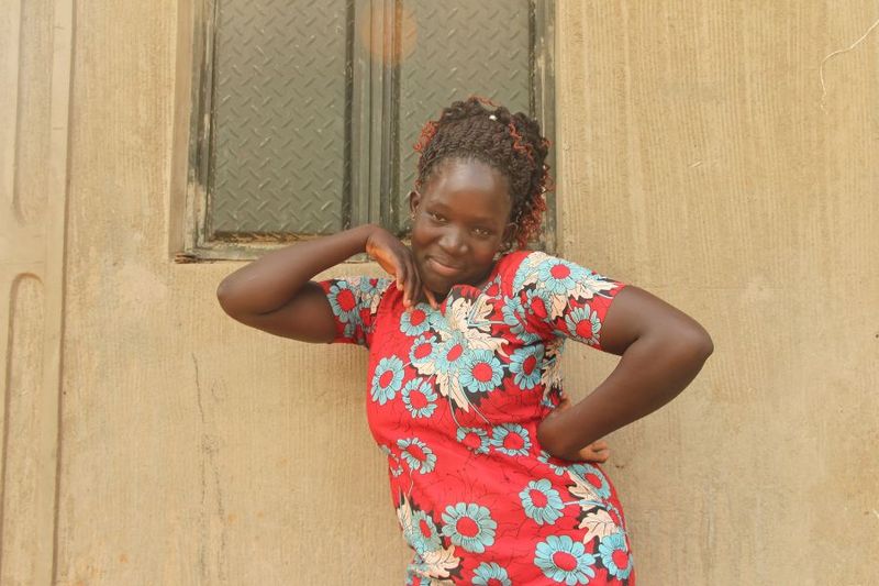 Lonah strikes a modeling pose while she shows off one of her fashion creations that she's wearing.