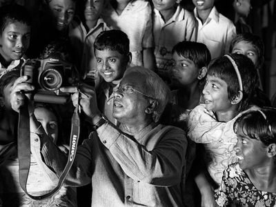 Sir Fazle Hasan Abed shows a group of children images taken on a camera