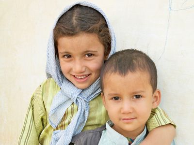 Smiling children stand outside in Afghanistan