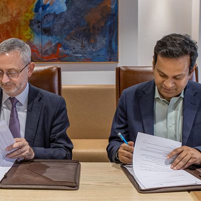 Leaders from BRAC and the European Union sit at a table while signing an agreement.