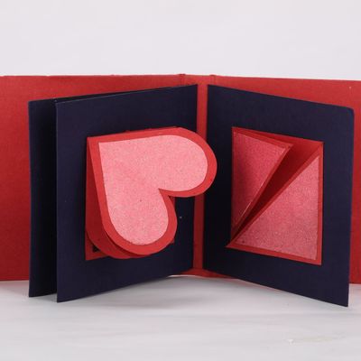 A red card opens up to show a hidden blue heart