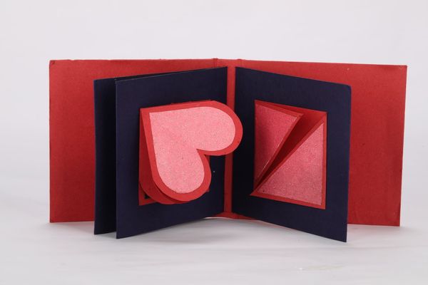 A red card opens up to show a hidden blue heart