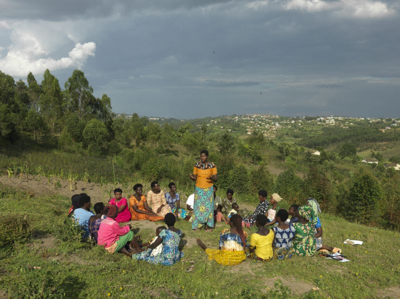 A group of women in Rwanda gather as one of them delivers a speech