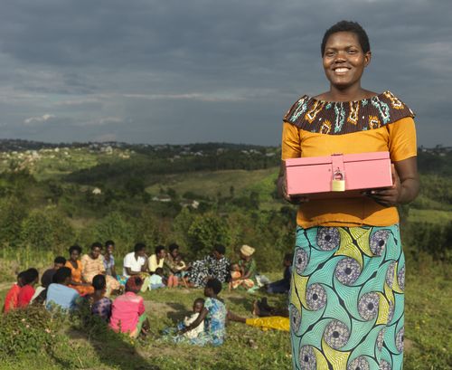BRAC Rwanda UPGI participant standing while holding locked box