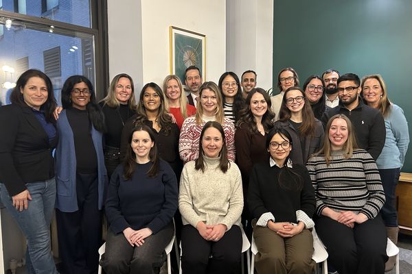 Twenty-one members of BRAC USA's team stand together in their office