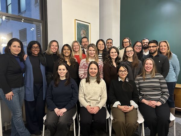 Twenty-one members of BRAC USA's team stand together in their office