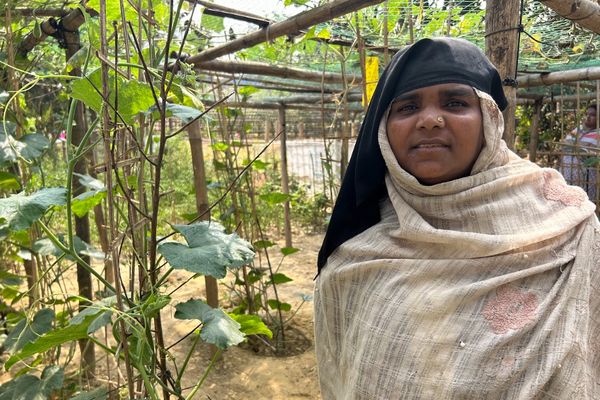 A woman stands in her lush, green garden
