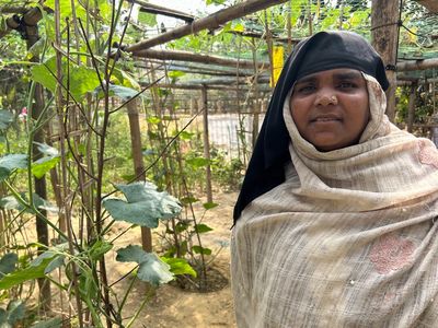 A woman stands in her lush, green garden