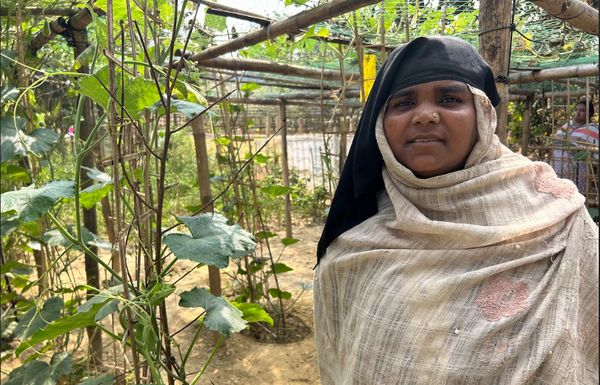 A woman stands in her lush, green garden