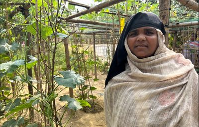 A woman stands in her lush, green garden
