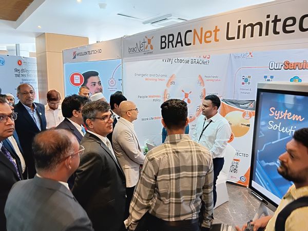 A group stands at a BRAC Net demonstration booth at a conference