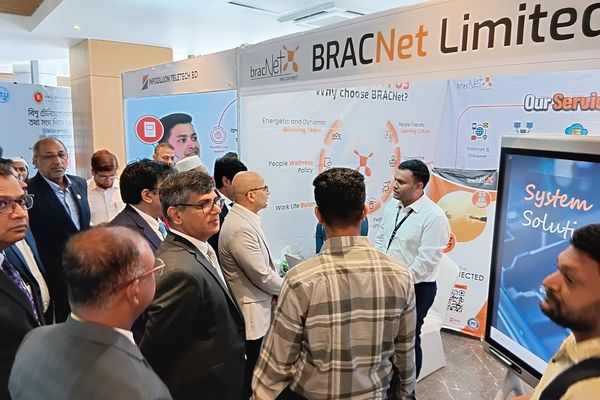 A group stands at a BRAC Net demonstration booth at a conference