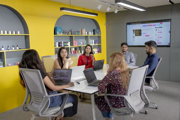 A group of professionals sit in a bright conference room for a meeting