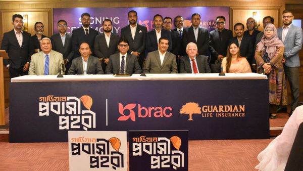 A group stands together to celebrate the new agreement between BRAC and Guardian