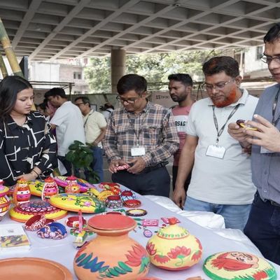 A small group of people stand around a table displaying decorated items
