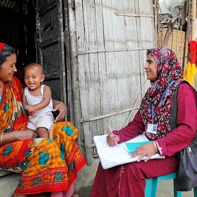 A community health worker consults a mother and her baby in Bangladesh
