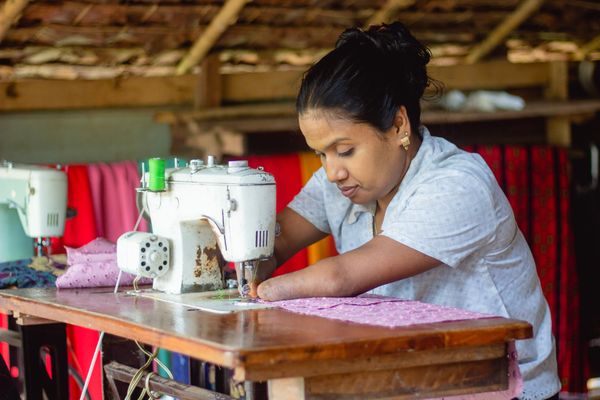 Zin, a participant in BRAC's microfinance program in Myanmar, sews diligently at her machine.