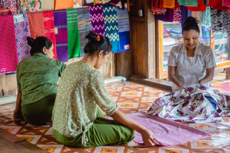 Zin teaches two women how to sew.
