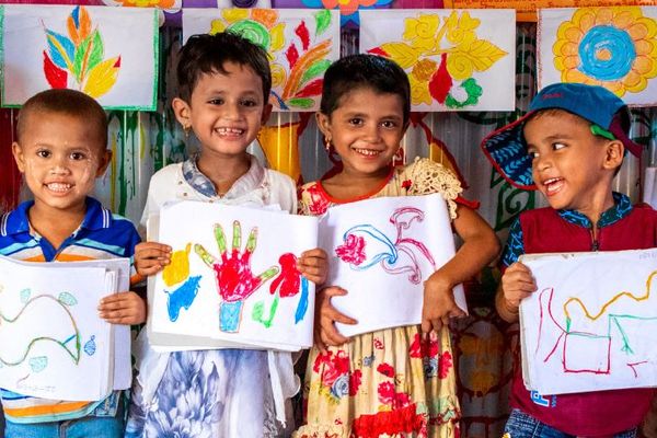 Rohingya children hold paintings at BRAC Humanitarian Play Lab at Cox's Bazar
