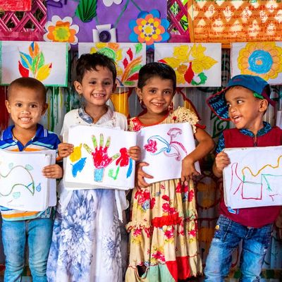 Rohingya children hold paintings at BRAC Humanitarian Play Lab at Cox's Bazar