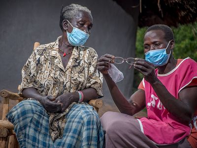 A health worker inspects a pair of glasses for a patient in Uganda.