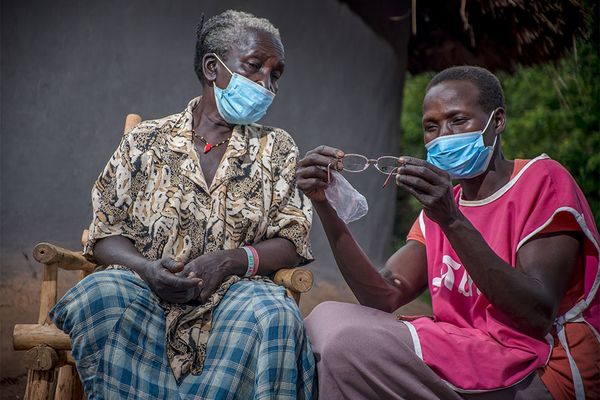 A health worker inspects a pair of glasses for a patient in Uganda.
