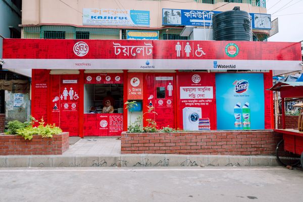 An outside view of Bhumijo's bright red public bathroom site in Dhaka's Mirpur neighborhood is shown