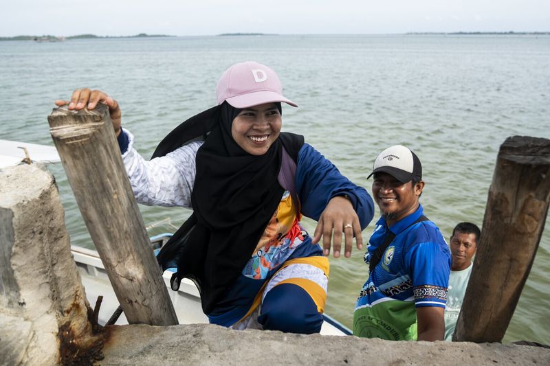 Darwina S. Tusay, AKAP Learning Facilitator for Grade 1, climbs the stairs after riding a speedboat in Tawi-Tawi, Bangsamoro Autonomous Region in Muslim Mindanao (BARMM), Philippines, on October 22, 2024. Photo by Lisa Marie David