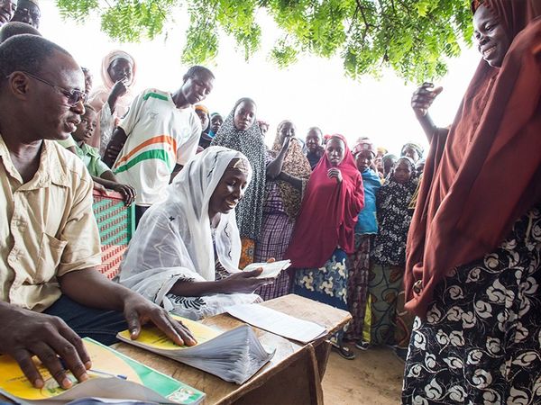 People taking part in a poverty-reduction trial in Niger receive cash and record-keeping booklets.Credit: Andrea Borgarello for World Bank