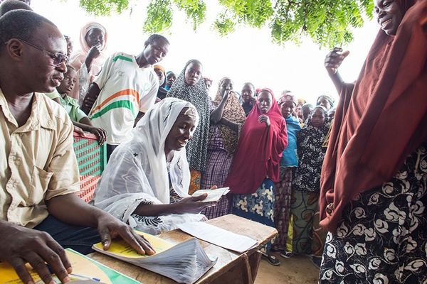 People taking part in a poverty-reduction trial in Niger receive cash and record-keeping booklets.Credit: Andrea Borgarello for World Bank