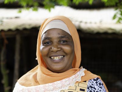 Woman microfinance client in Tanzania with bright smile on her face
