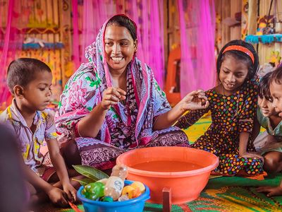 A Play Leader facilitates a sensory play activity with a small group of children in a BRAC Play Lab.