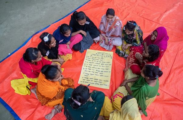 An overhead view shows a small group of girls learning about their rights
