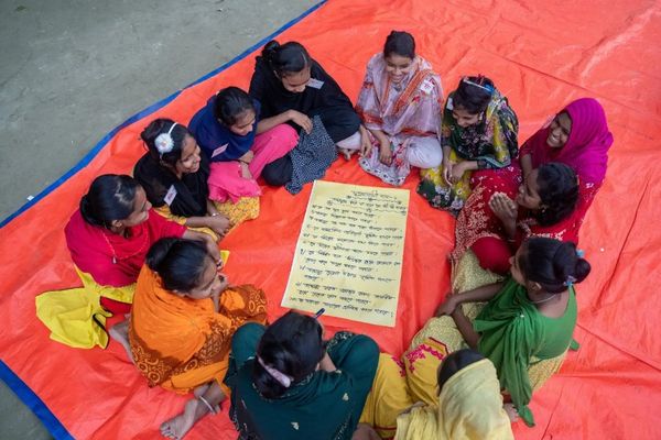 An overhead view shows a small group of girls learning about their rights