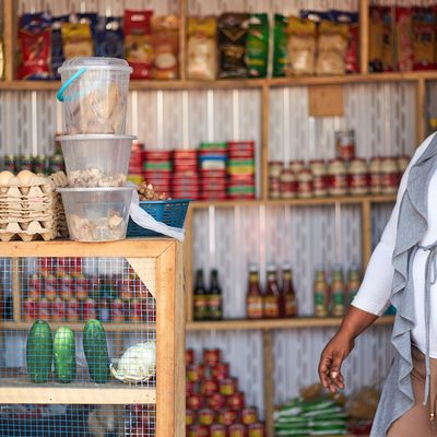 Sophia, a microfinance borrower in Ghana, stands in her shop.