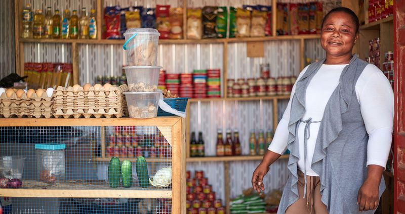 Sophia, a microfinance borrower in Ghana, stands in her shop.