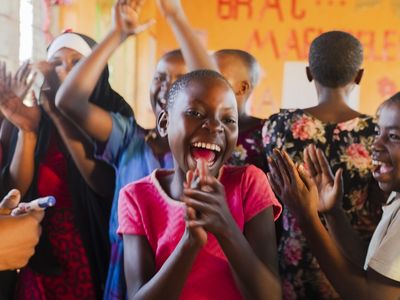 A young girl from AIM dancing and clapping