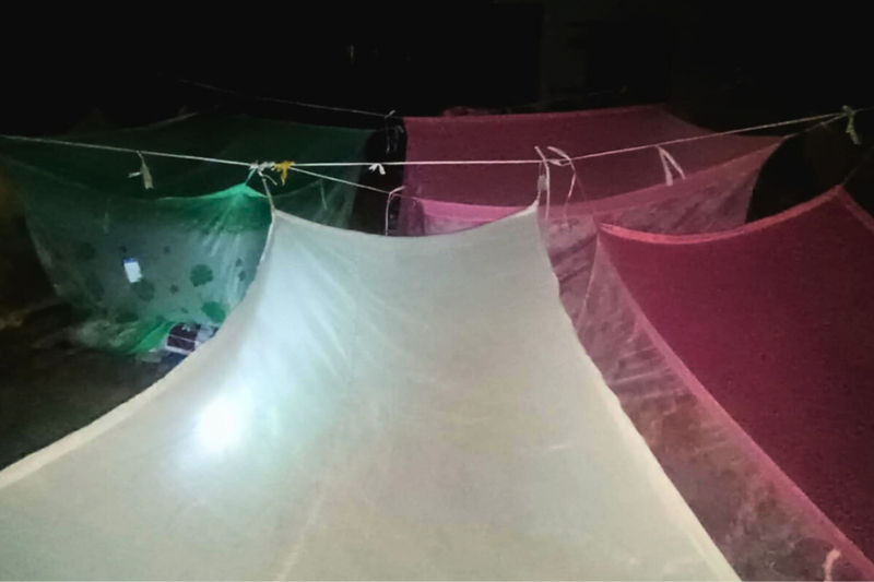 A collection of tents in the darkness is shown where BRAC staff are sleeping at night.