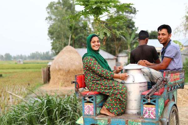 Woman & man in Bangladesh transporting milk - BRAC Dairy social enterprise