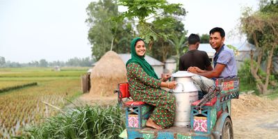 Woman & man in Bangladesh transporting milk - BRAC Dairy social enterprise
