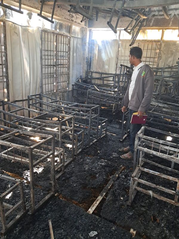 wreckage left after Cox's Bazaar fire, man stands in middle of burned out classroom