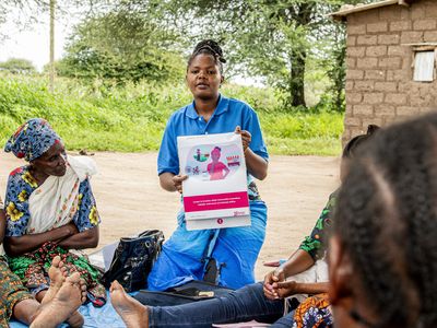 Microfinance FLT - woman holds sign up for other women to read