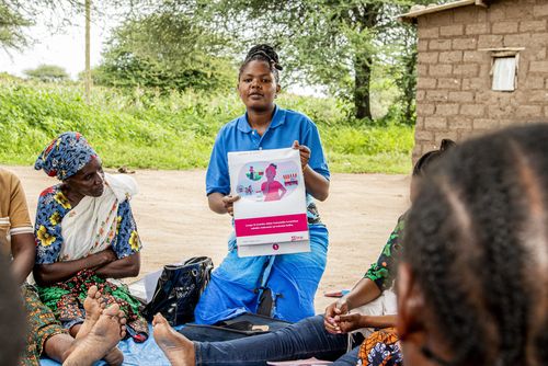 Microfinance FLT - woman holds sign up for other women to read