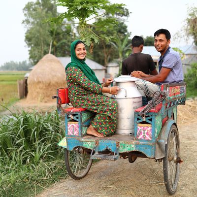 BRAC Bangladesh man and woman sitting on a dairy cart